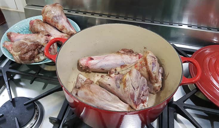 Lamb shanks being browned in casserole pot