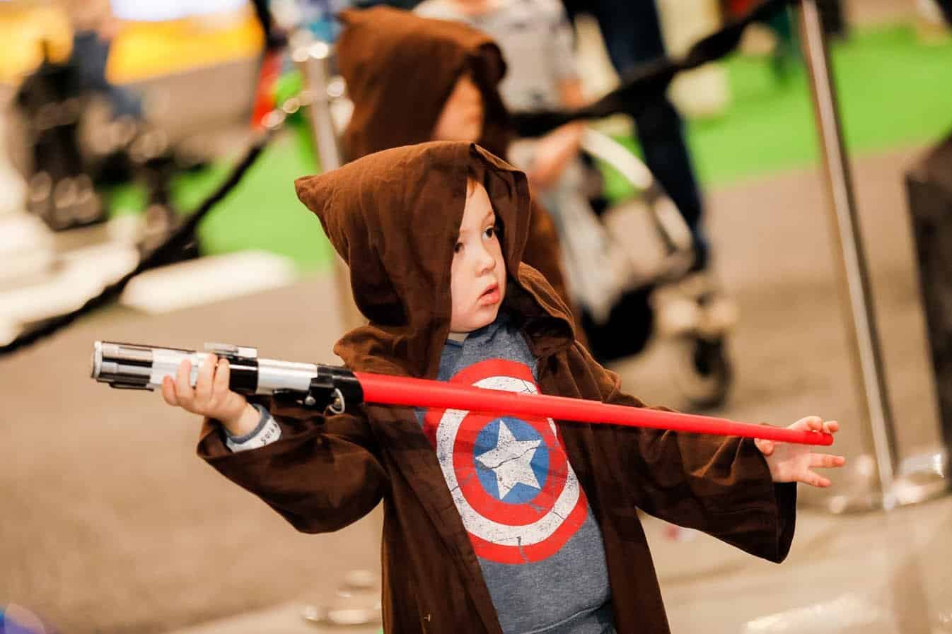 Child in hoodie with red light saber