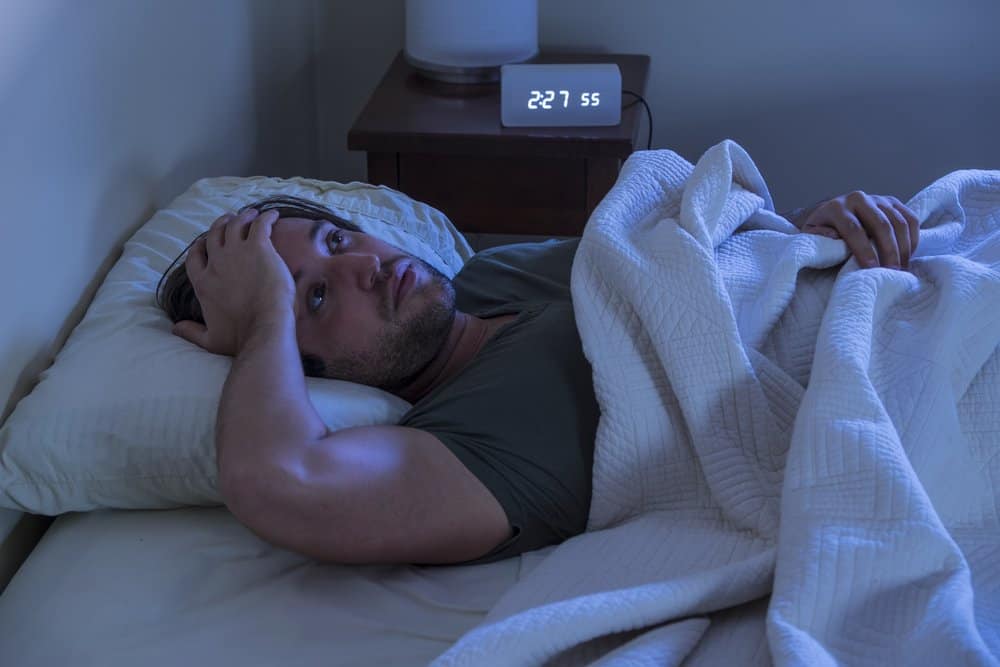 Man in bed having trouble sleeping
