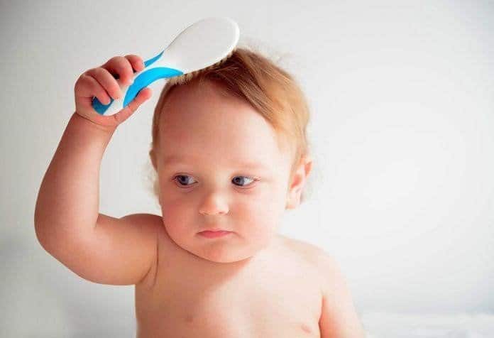 Toddler brushing their own hair