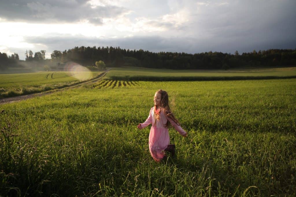 kid running on green fields