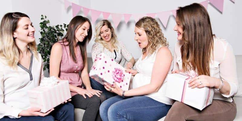 Expecting mum receiving gifts from friends on baby shower