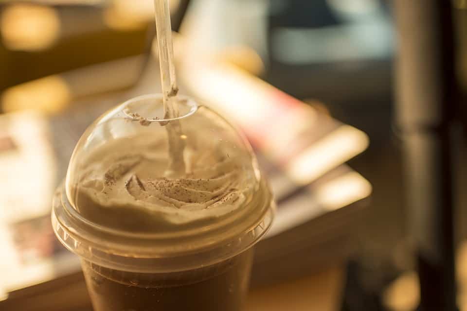 Iced latte in a plastic cup with a straw