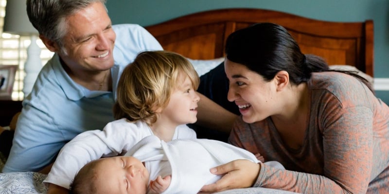 happy family on a bed with baby