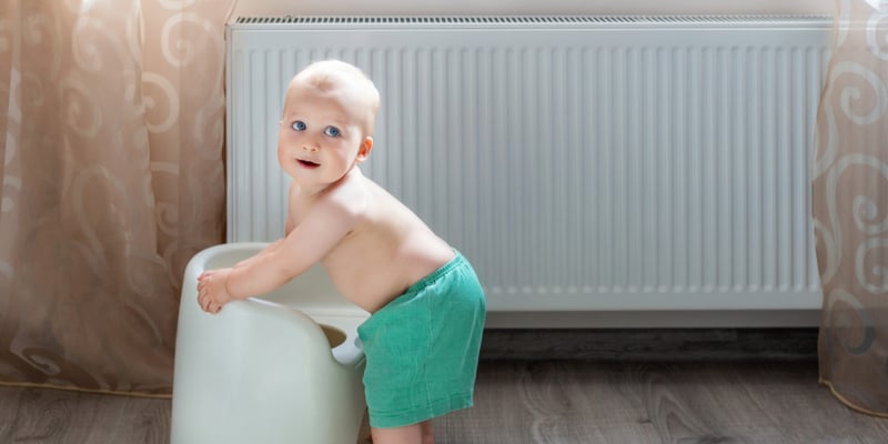 Toddler playing beside a heater on baby room