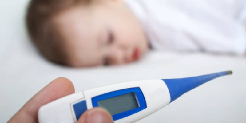 mother checking child's fever using baby thermometer
