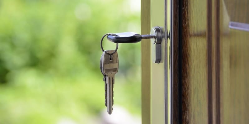 close up shot of house key in door (1)