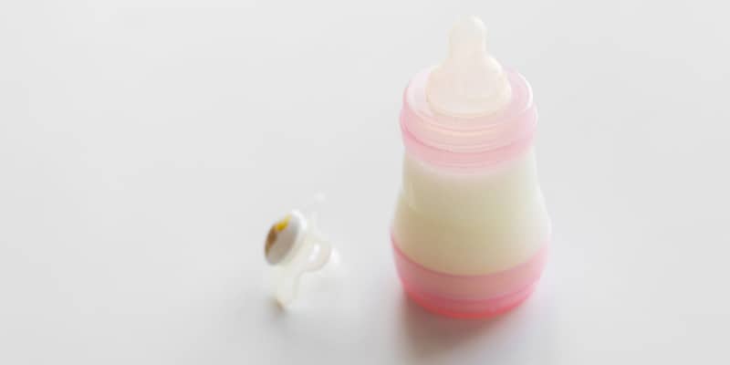 Milk in plastic baby bottle and pacifier