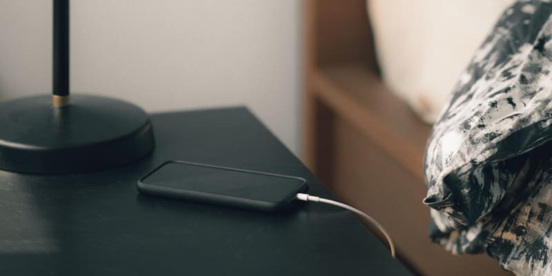 mobile phone charging on bedside table