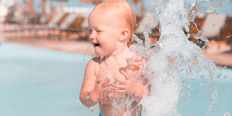 Happy kid playing in water park