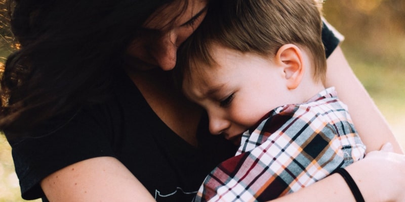 Mother holding crying son