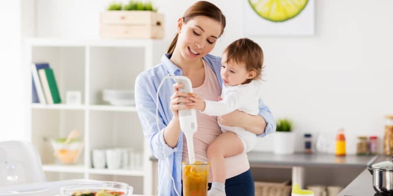 Mum carrying baby blending food