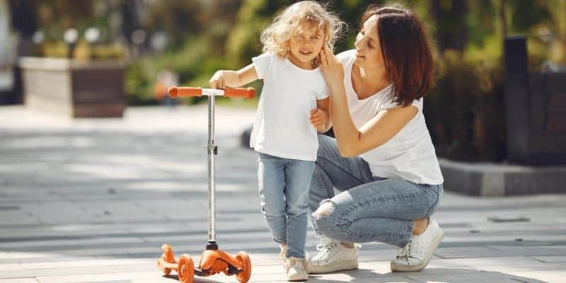 Mother and daughter playing with scooter