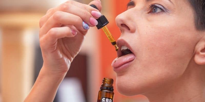 Woman using CBD oil for acne care