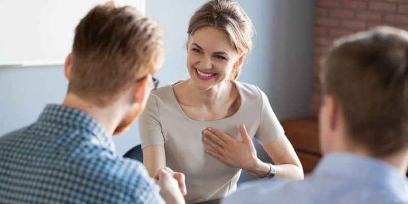 Woman smiling while talking to manager at work