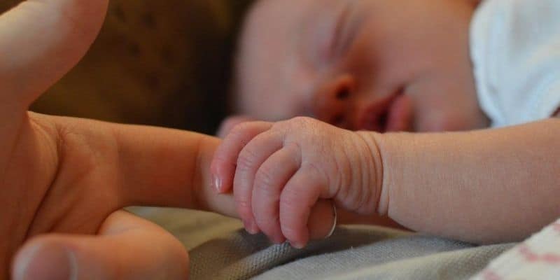 Baby holding on to mother's finger