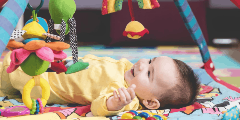 Adorable baby looking at colorful toys