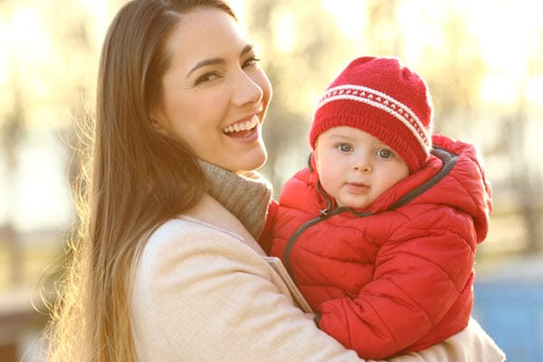 Mother with baby wearing red beanie and warm puffer jacket for winter