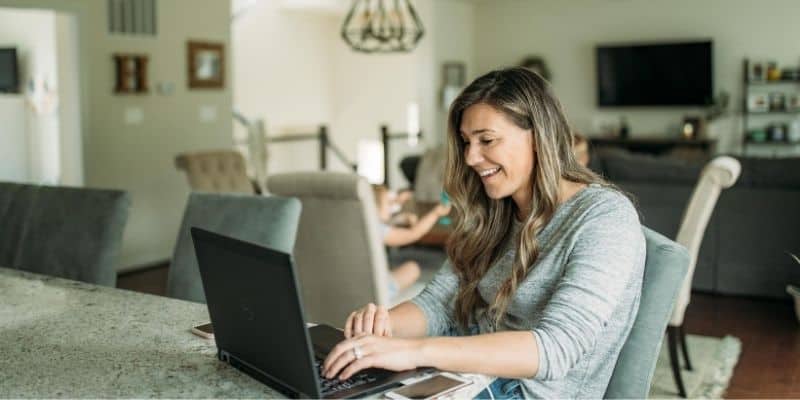 Mother working from home with kids in the background
