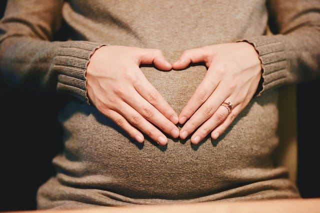 Pregnant woman with hands on tummy