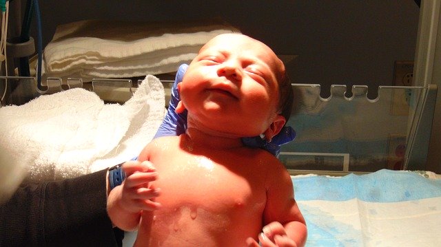 Doctor holding adorable newborn baby