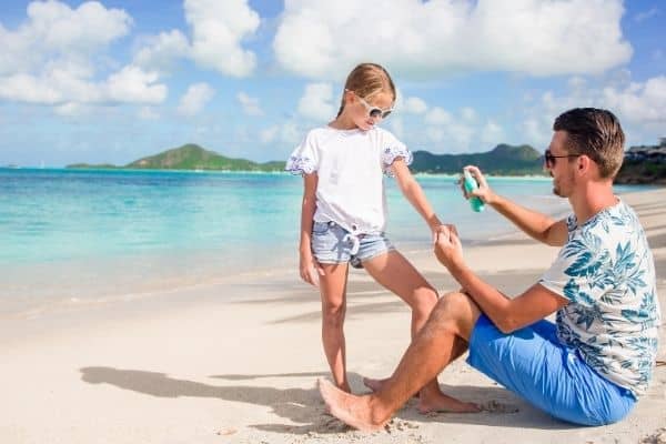 Parent applying sunscreen on child