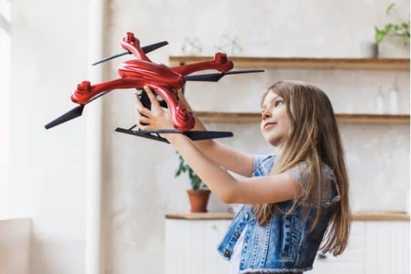 Young girl holding red drone