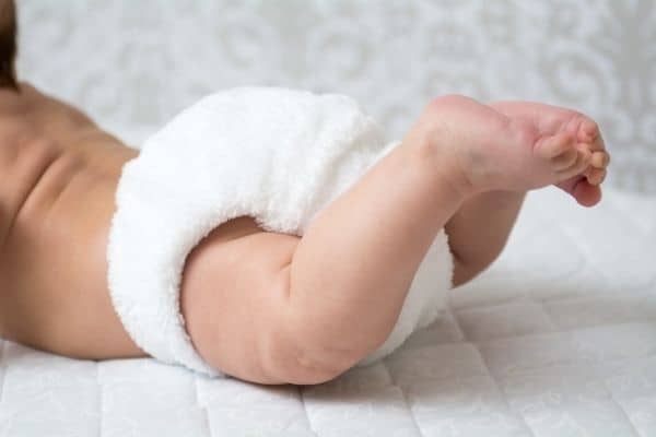 Baby wearing white reusable nappy cloth