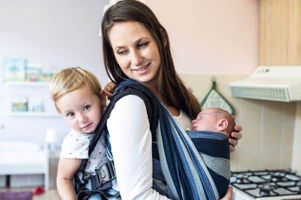 Mother with baby and toddler on carrier