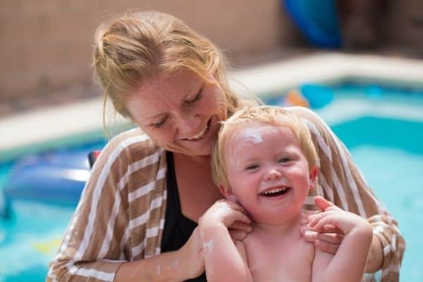 Mother and son applying lotion