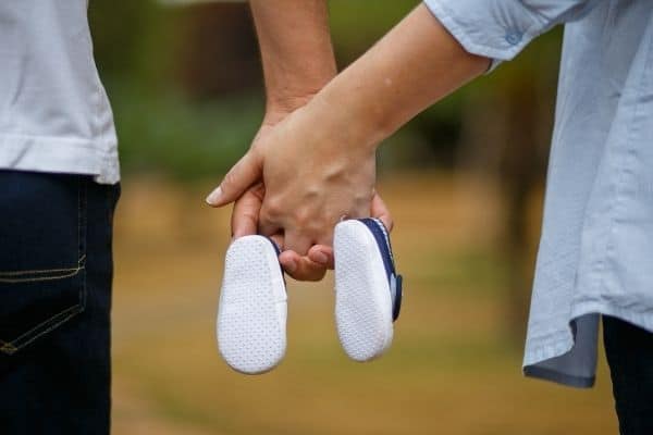 Couple holding baby shoes