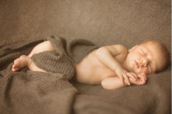 Sleeping baby with baby swaddle as blanket