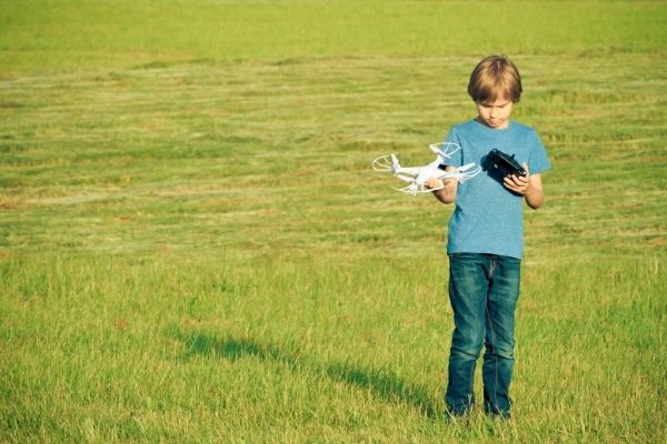 Child with white drone outdoors