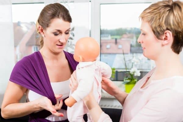 Women learning how to use baby sling