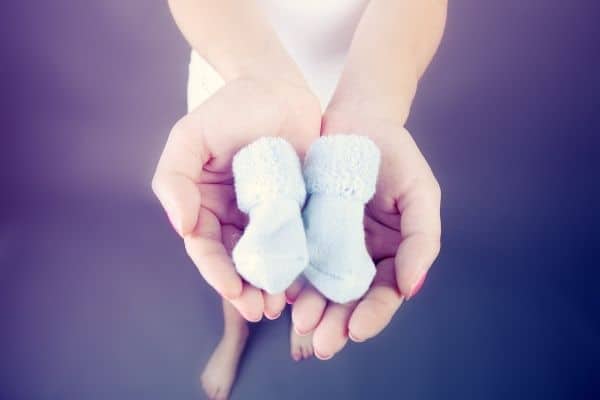 Person holding newborn shoes