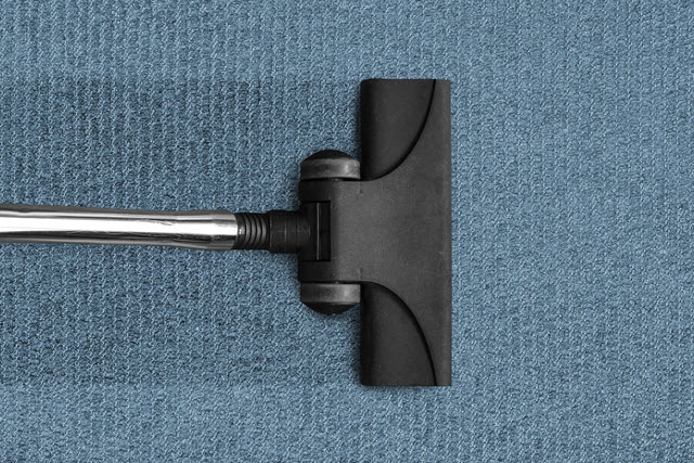 Vacuum cleaner on blue carpet