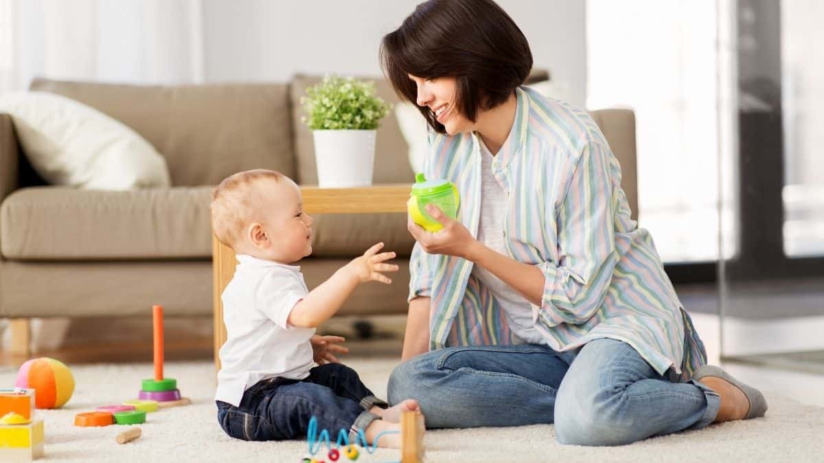 Parent giving sippy cup to child