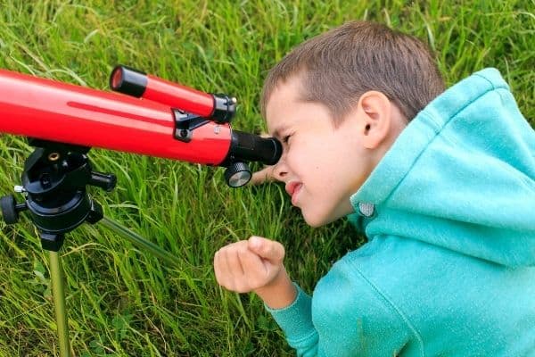 Young boy using a telescope for beginners