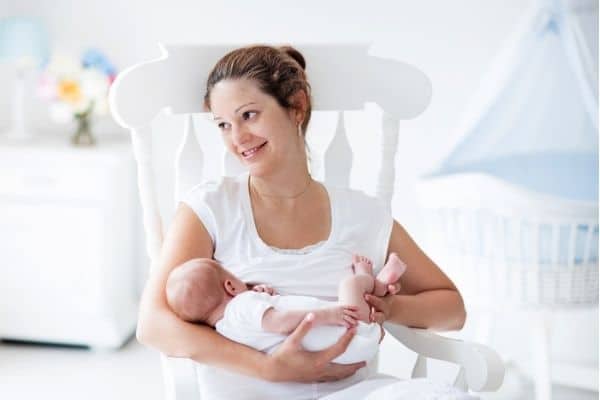Mum and baby on white nursing chair with armrest
