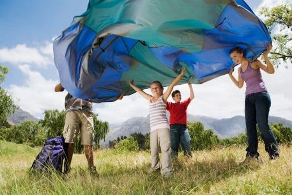 Parents and kids setting up family tent