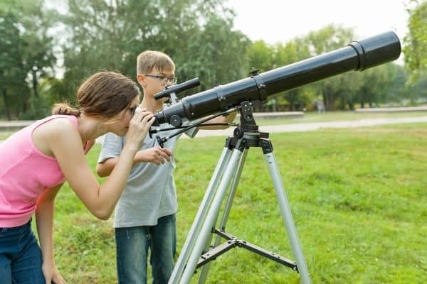 Kids using telescope outdoors