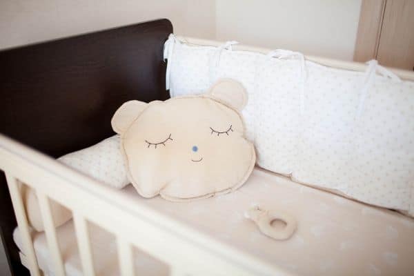 A cot bed with cute pillow