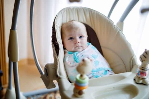 Child on a baby swing with additional functions