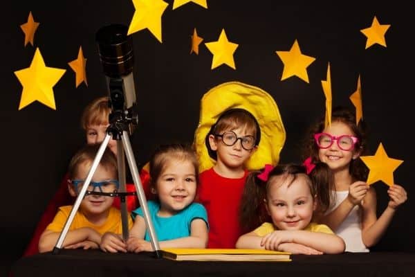 Children with telescope and stars in the background