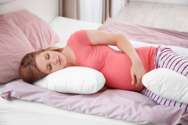 Woman sleeping on pregnancy pillow