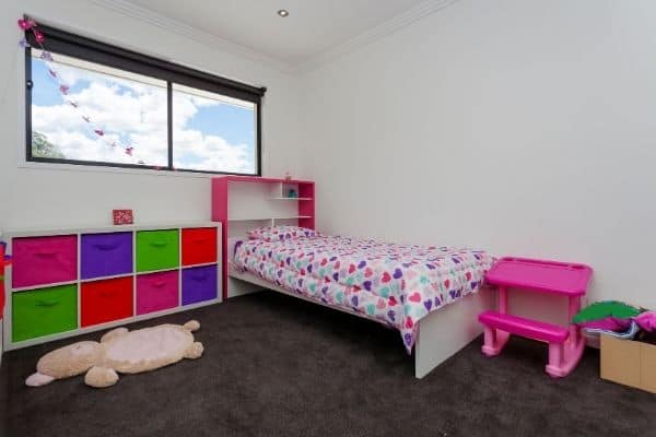 Kids bedroom with colorful toddler bed and cabinet