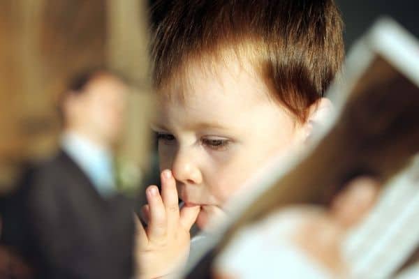 Sad child with wedding photo being torn in the background