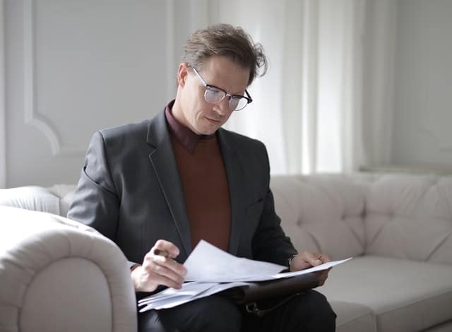 A professional wearing glasses studying documents