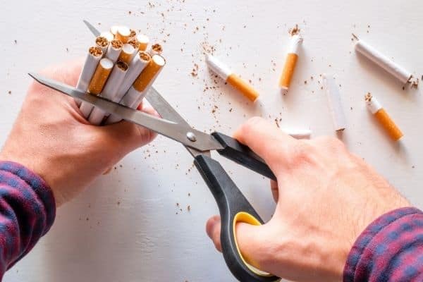 Person cutting up cigarettes