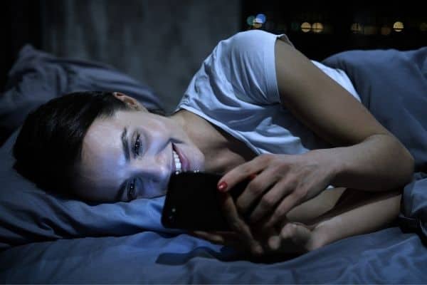 Woman smiling while using mobile phone